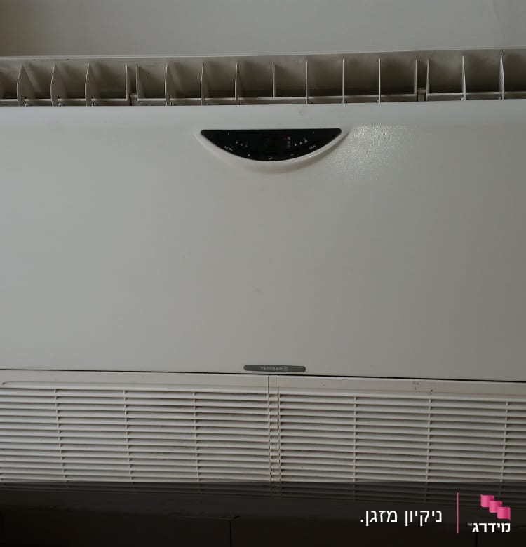 מזגן קיר לבן עם פתחי אוורור עליונים ותחתונים